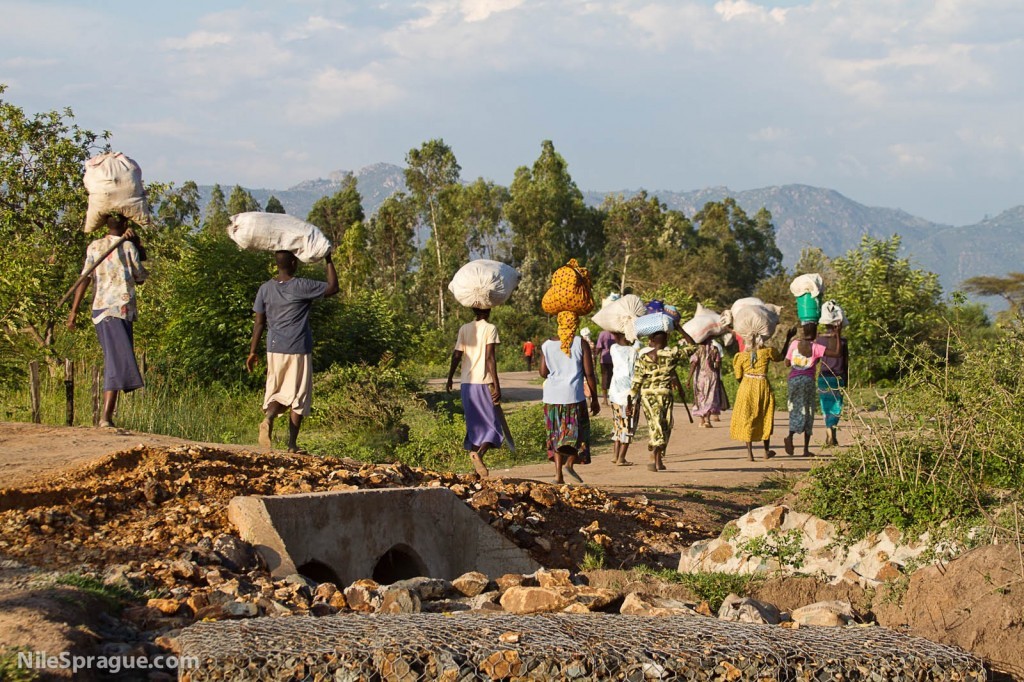 Women carrying sacks on their heads after market, Kisumu, Kenya.